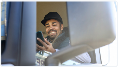 Driver using Dump Truck Dispatcher on mobile device in truck cab